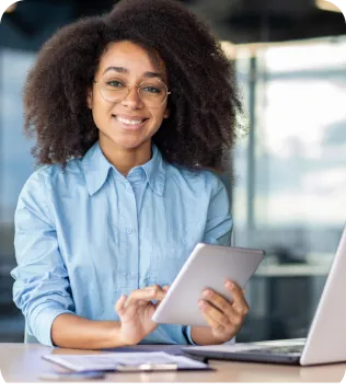 Lächelnde junge Finanzberaterin mit Tablet am Schreibtisch im modernen Büro