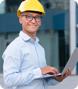 Bausachverständiger mit gelbem Helm und Laptop vor einem modernen Gebäude